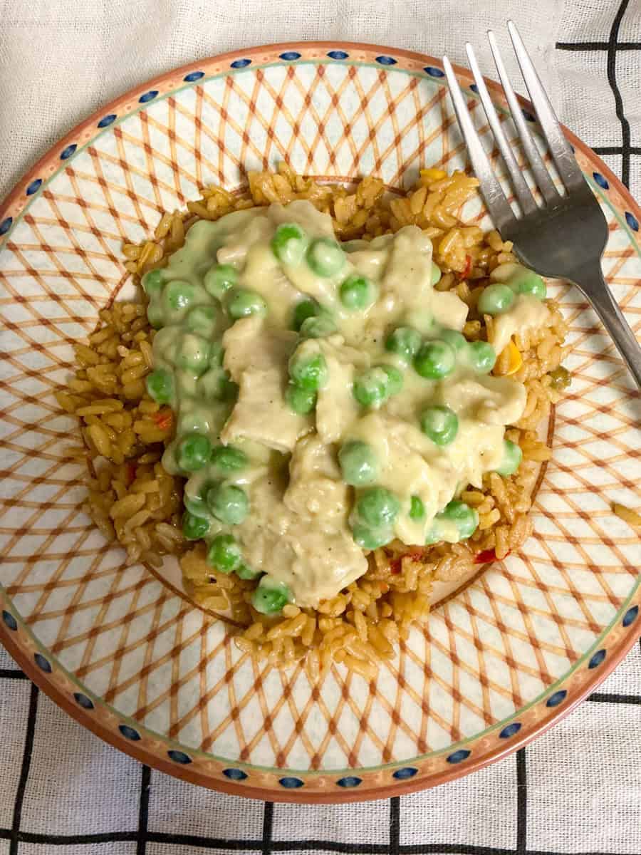 Vegan creamed chicken on rice served on plate with fork.