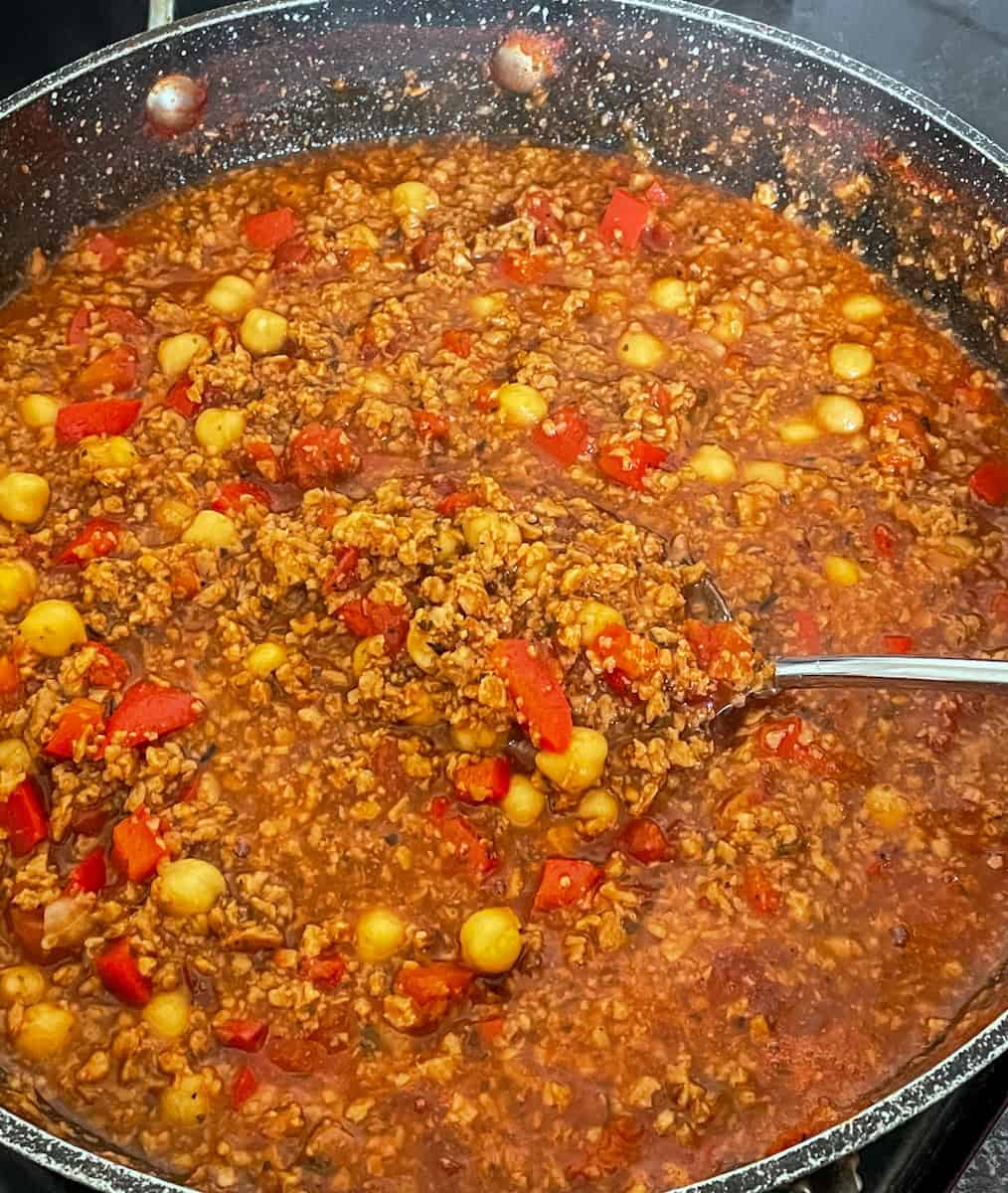 Beanfeast Bolognese cooked in pan and ready to serve with serving spoon.