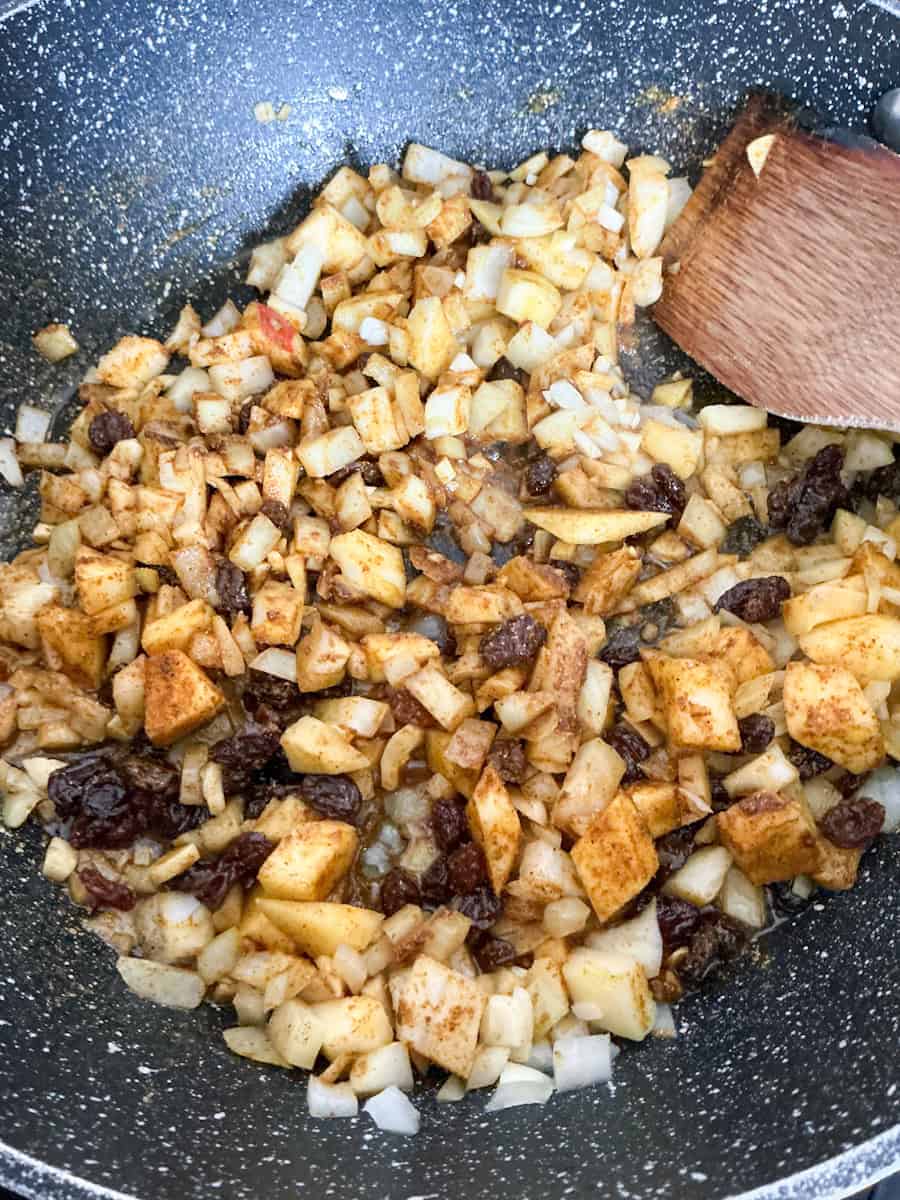 Cooking ingredients for curry in frying pan.