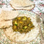 Featured image for lentil curry, served on a plate with flatbreads to side.
