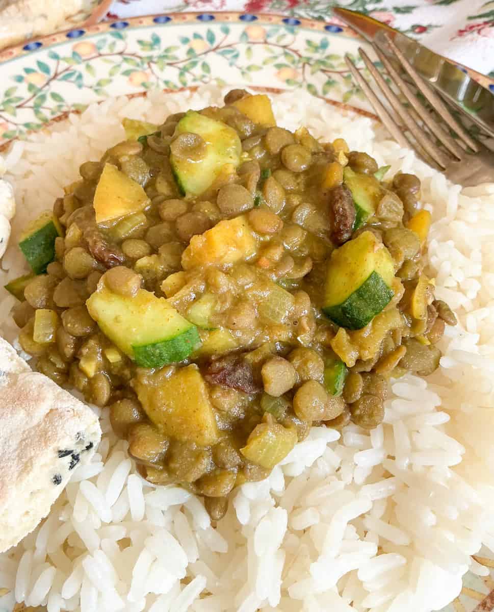 Lentil curry served with rice on plate.