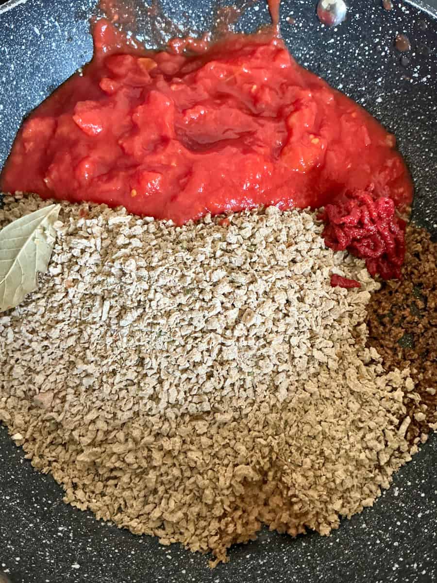 Beanfeast Bolognese dried mix added to pan with other ingredients.